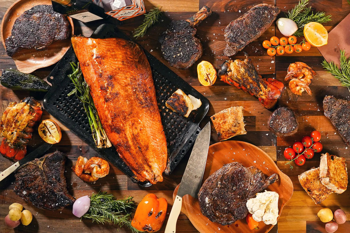 Assorted cooked meats and vegetables on a wooden cutting board with a knife.