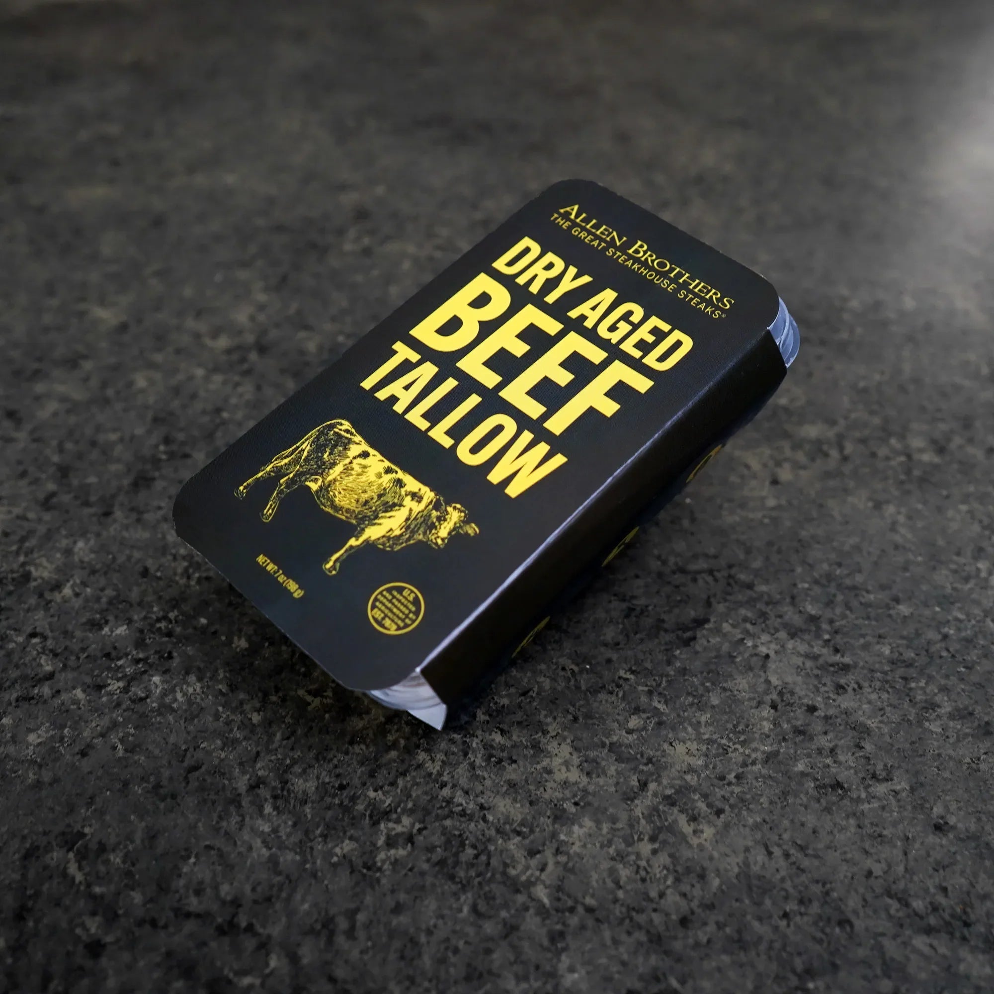 black package with yellow writing on dark marble surface