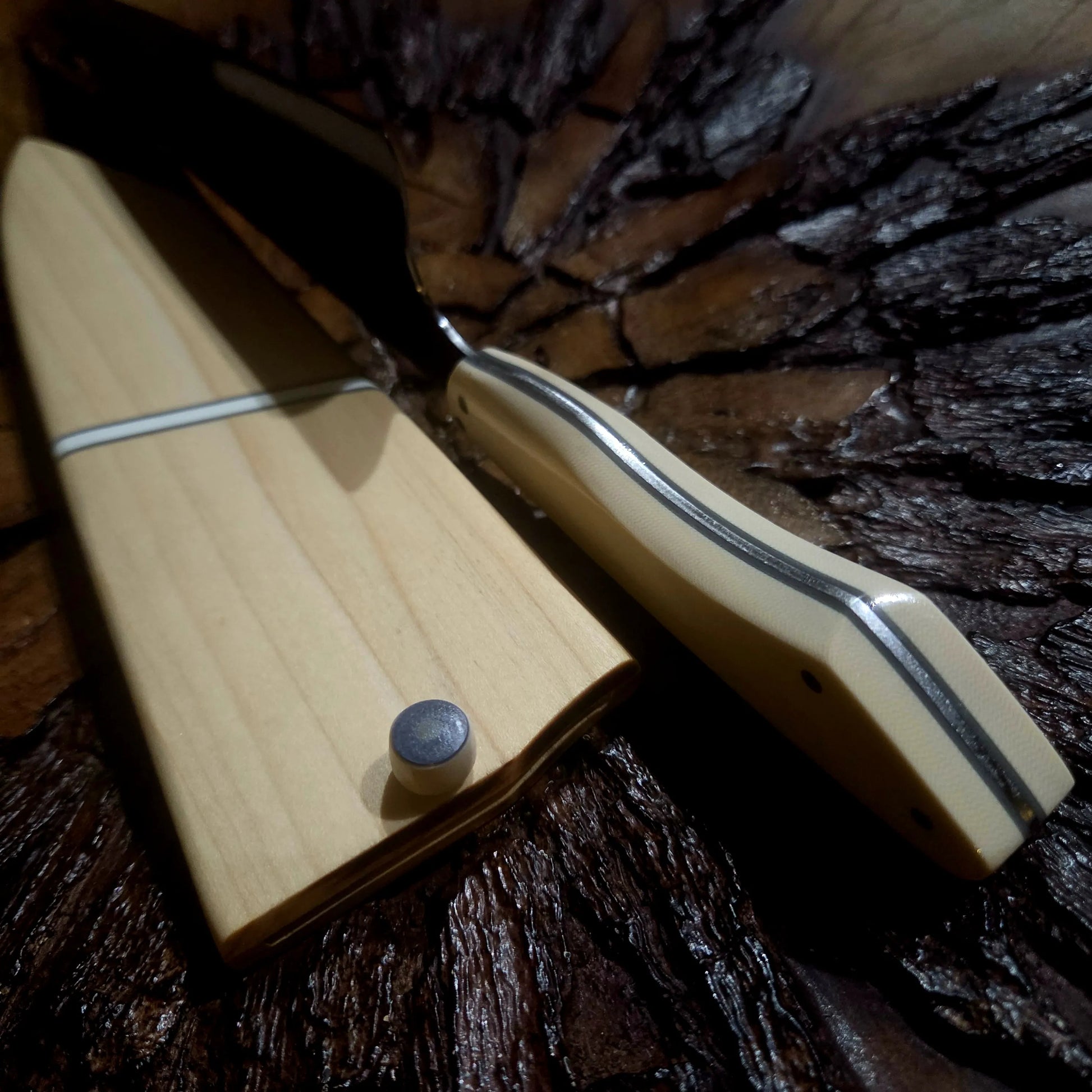 TH Blades Handcrafted 8 Chef Knife handles: light wood and tan G-10, displayed without blades on a textured dark surface.