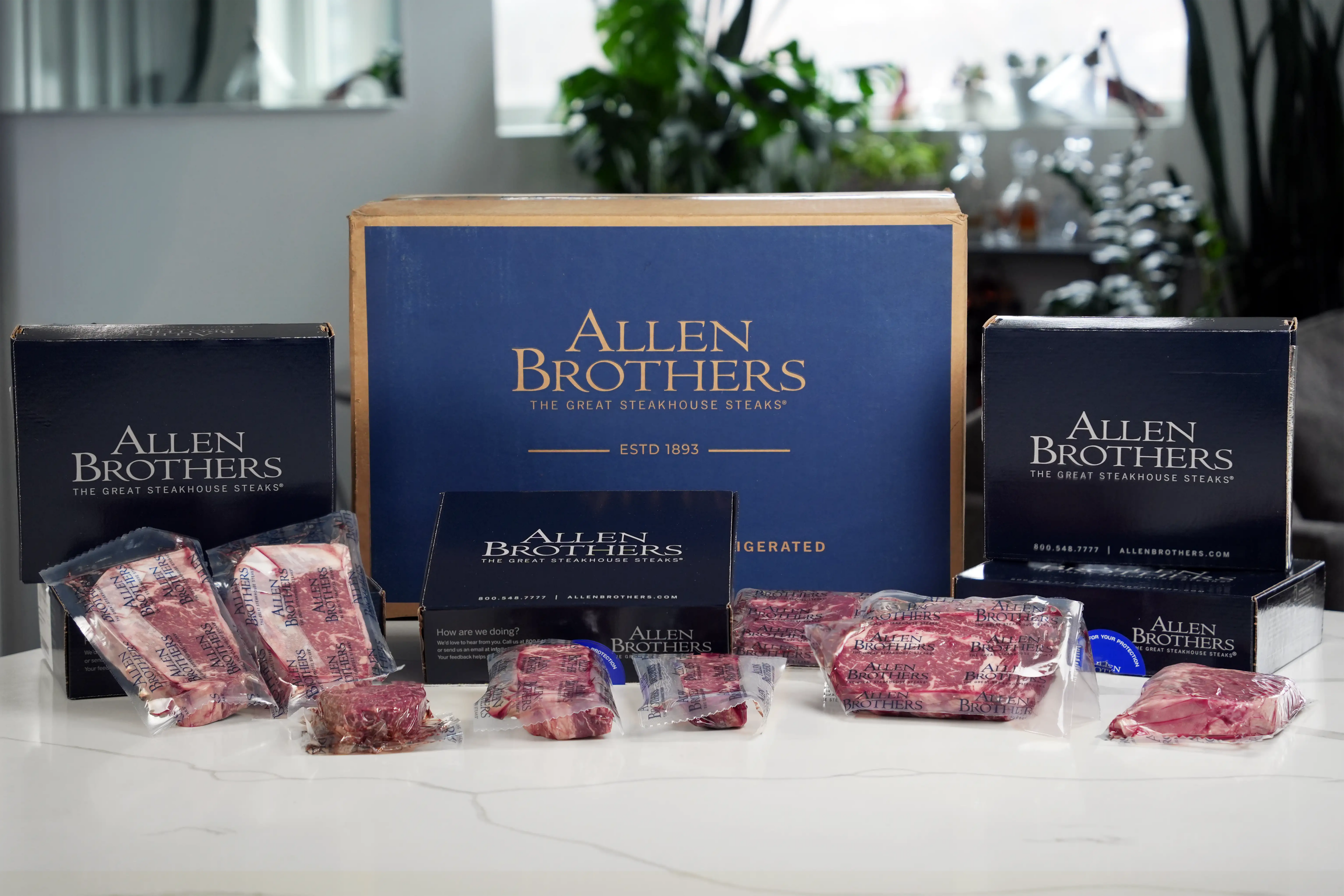 Allen Brothers beef packaging on a table with branded boxes in the background.