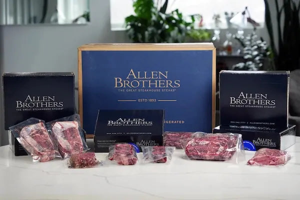 Allen Brothers meat packaging on a table with branded boxes in the background.