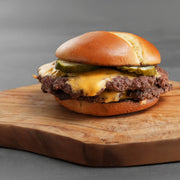 cooked burger on cutting board