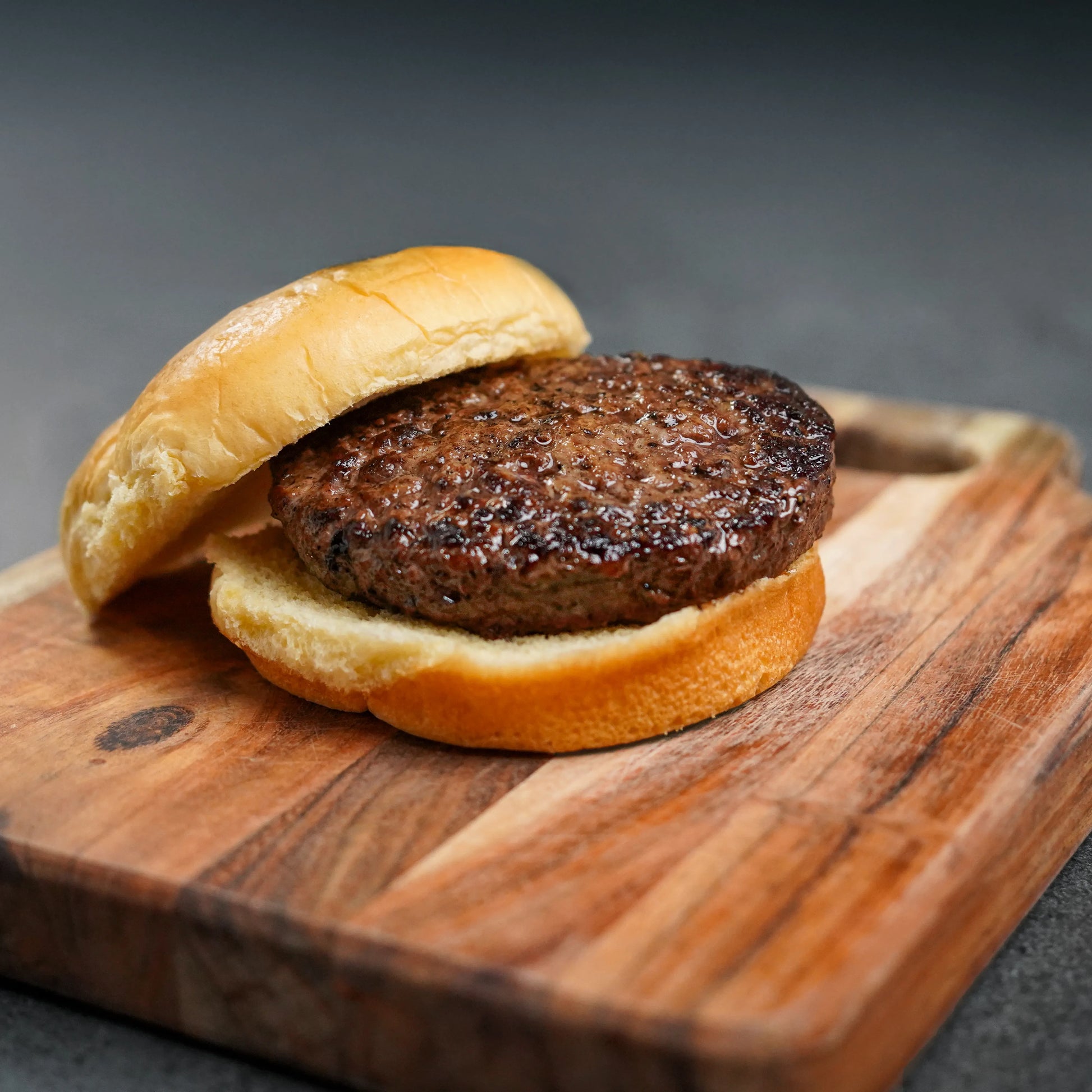 Choice Angus Steakhouse Blend Ground burger slider on a wooden board, showcasing a premium, lean patty between soft buns, ideal for versatile recipes and lighter dining.