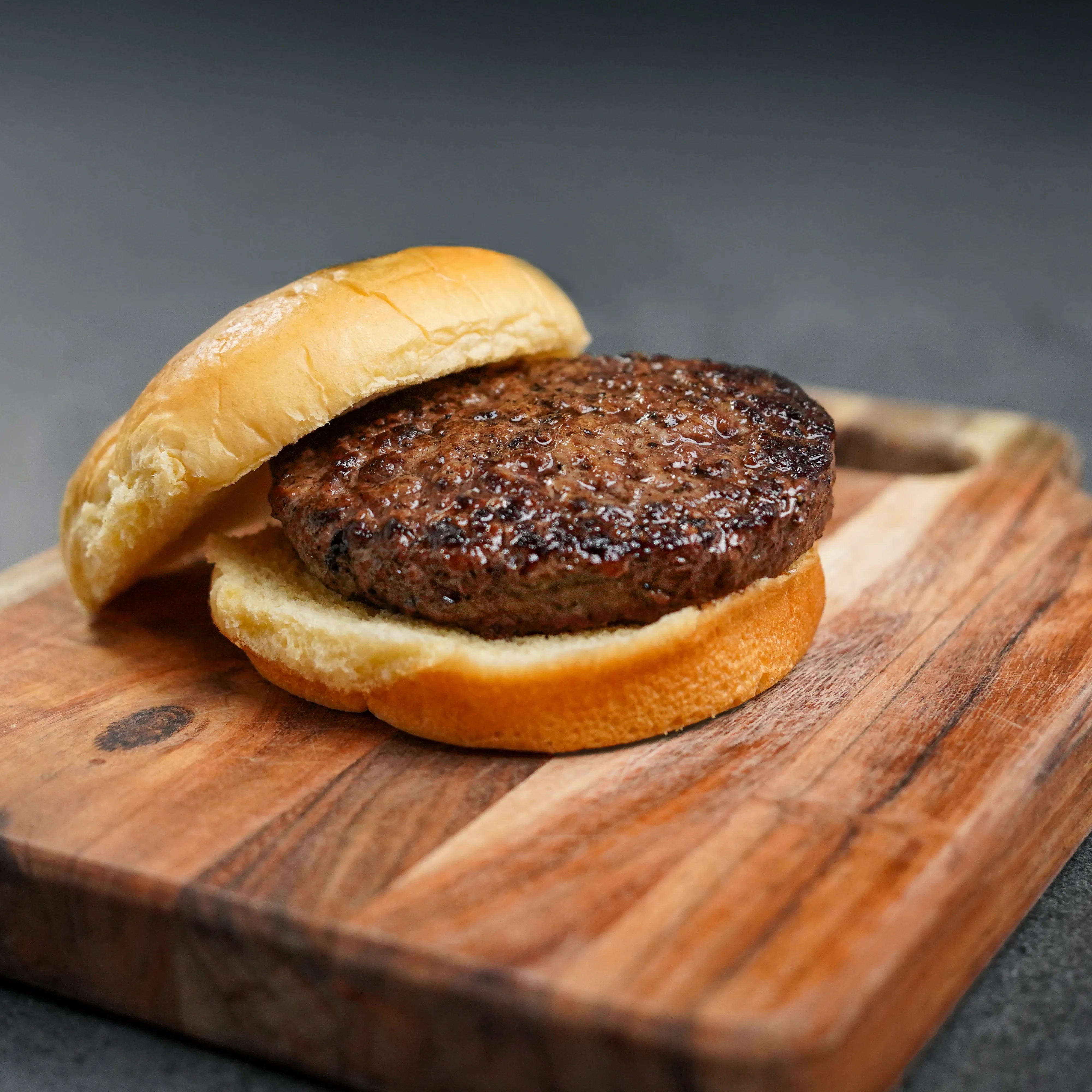 Choice Angus Steakhouse Blend Ground burger slider on a wooden board, showcasing a premium, lean patty between soft buns, ideal for versatile recipes and lighter dining.