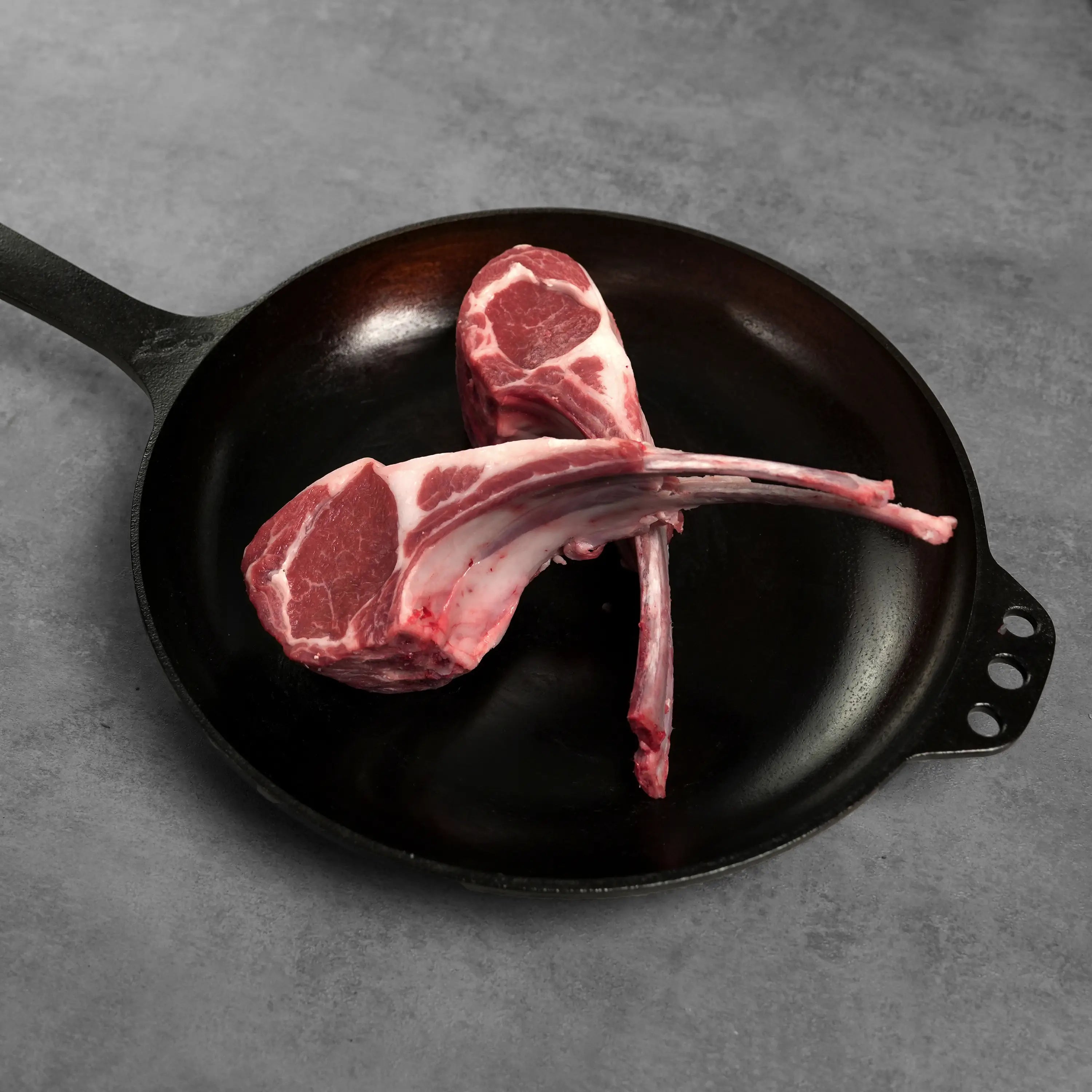 Allen Brothers Domestic All Natural Double Cut Lamb Chop raw on black pan