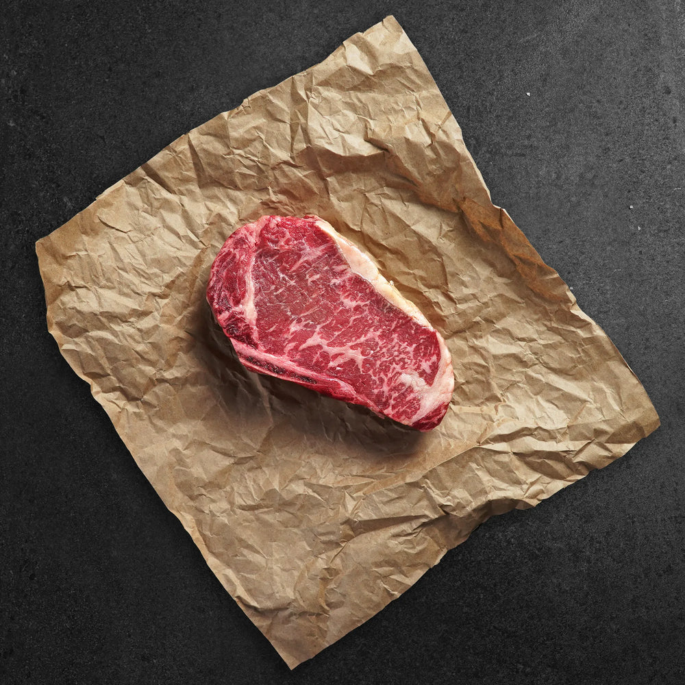 Raw steak on crumpled brown paper