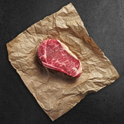 Raw steak on crumpled brown paper