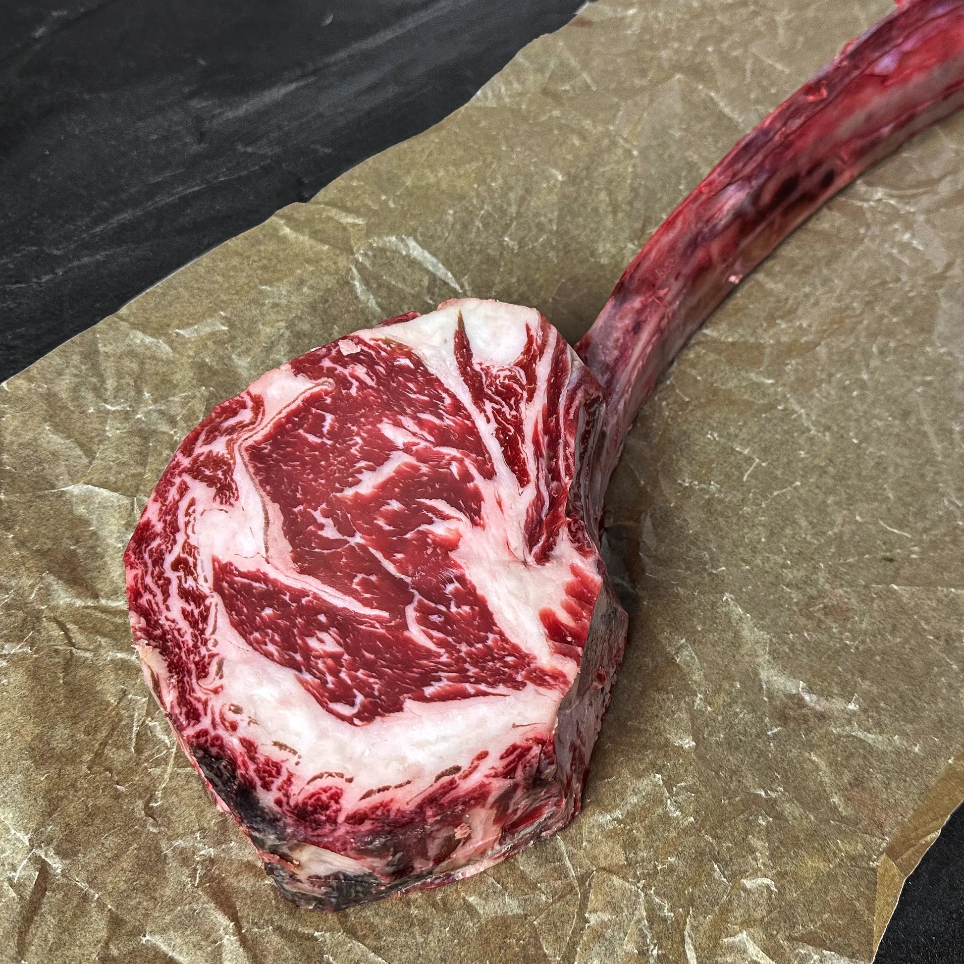 Marbled raw steak on a stone surface