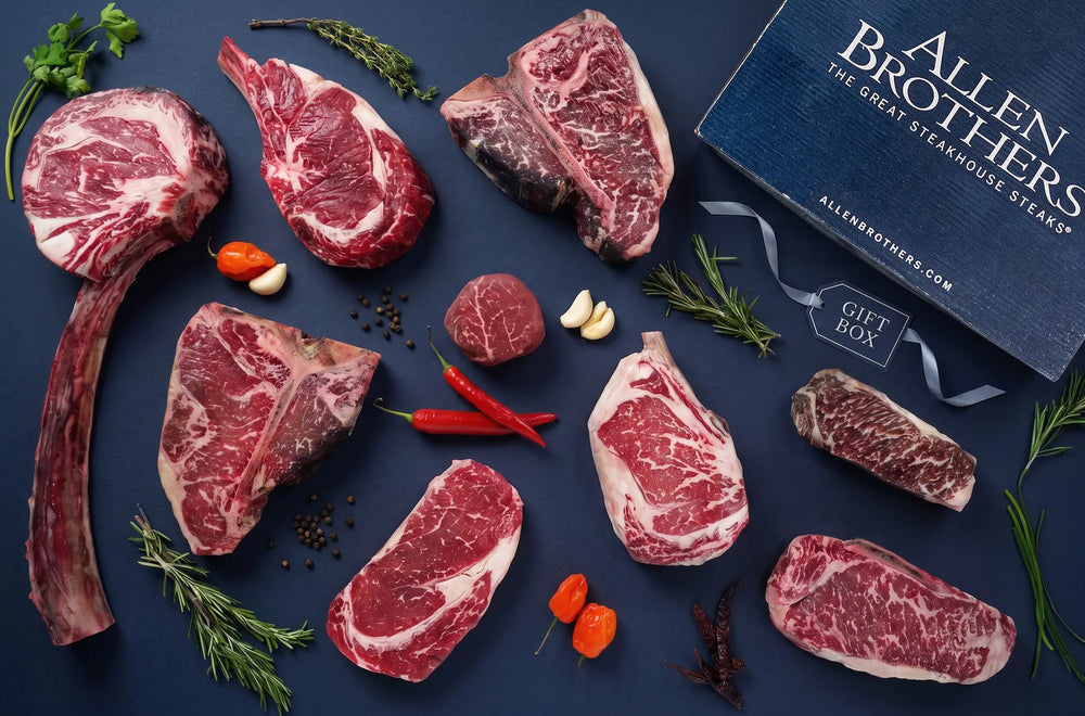 Assorted Allen Brothers steaks displayed alongside a branded gift box.