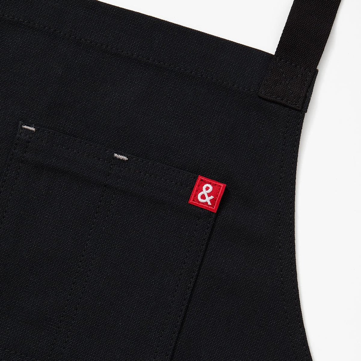 Black crossback apron front panel with small red logo patch