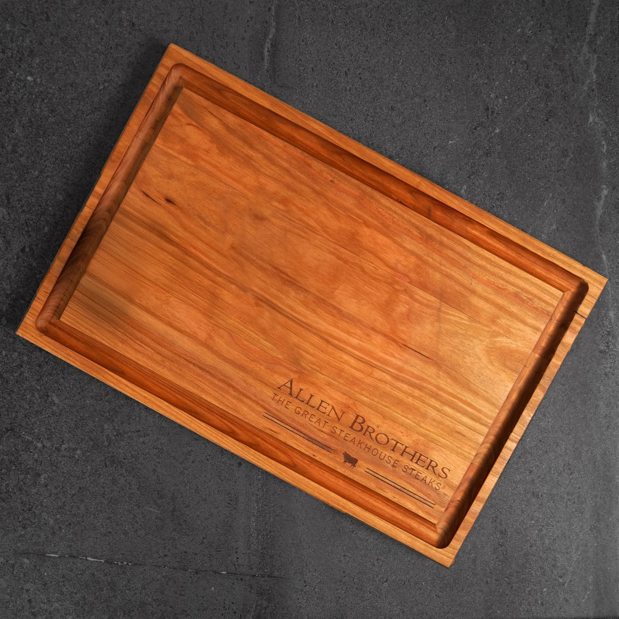 Father's Day Gift Box: Rectangular wooden serving board with Allen Brothers logo, ideal for presenting premium strip steaks and ribeyes, enhancing kitchen or backyard dining.