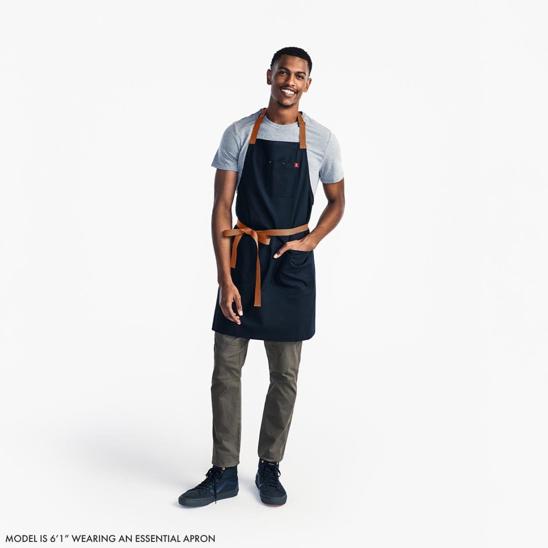 Midnight blue apron on model with adjustable neck strap and waist tie