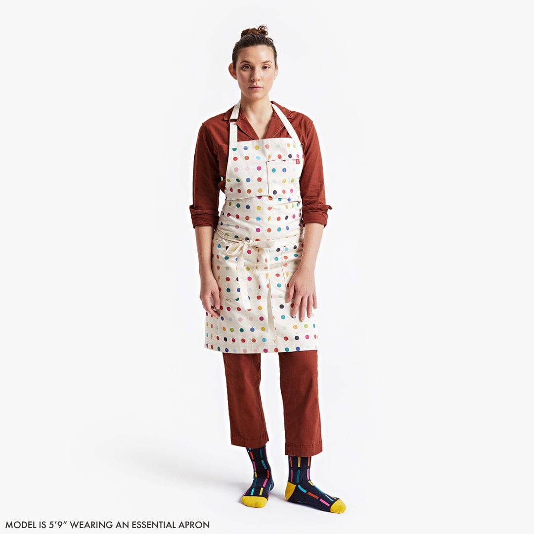 Person wearing a polka dot apron on a white background
