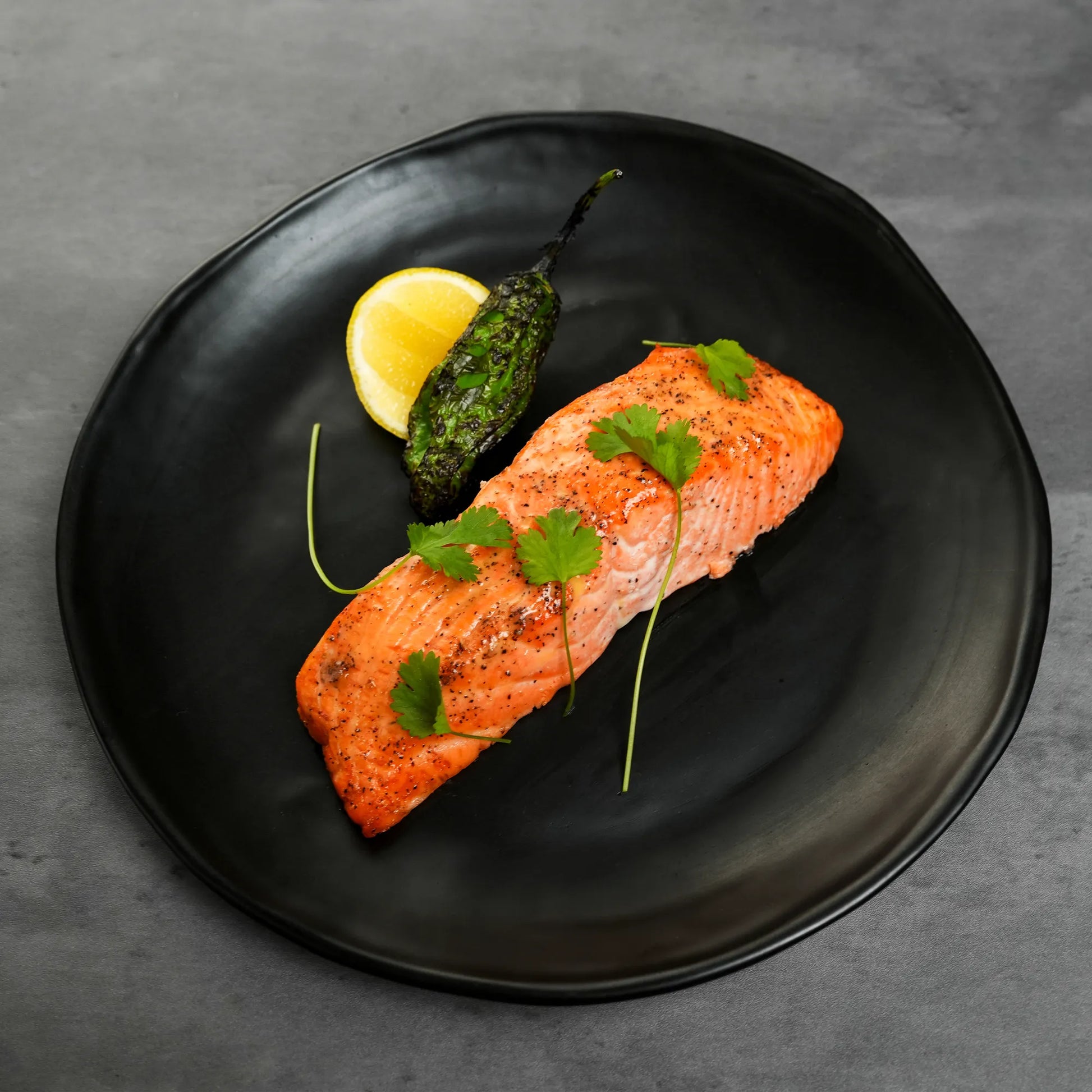 Cooked Foley Big Glory Bay Salmon Filets on a black plate