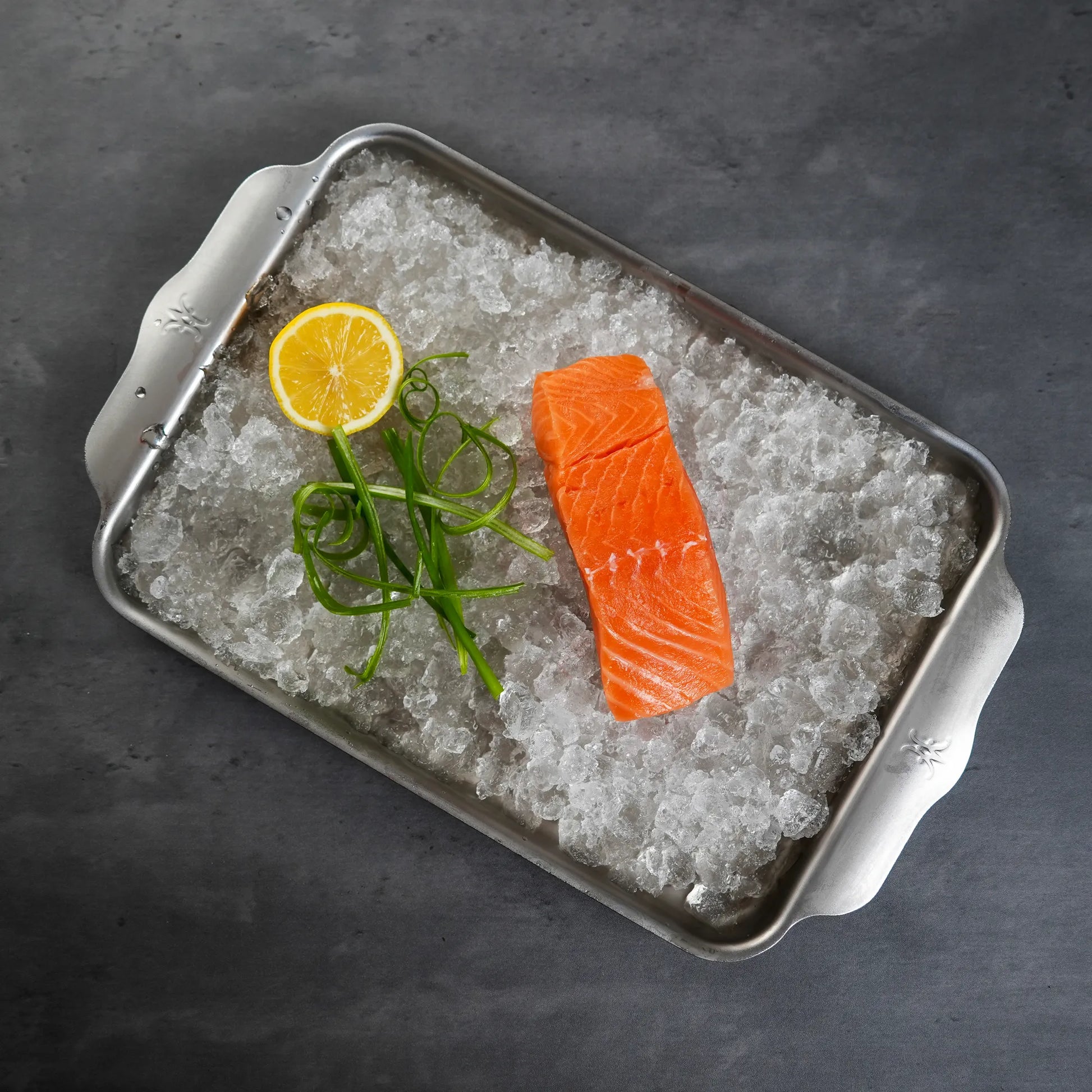 Raw Foley Big Glory Bay Salmon Filets on ice in a silver sheet pan
