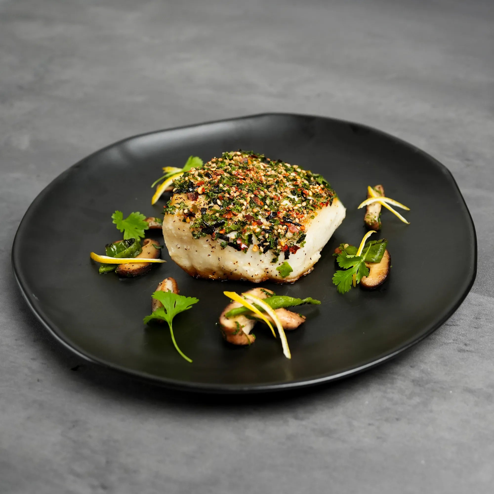 Cooked Foley Chilean Sea Bass Filets on a black plate