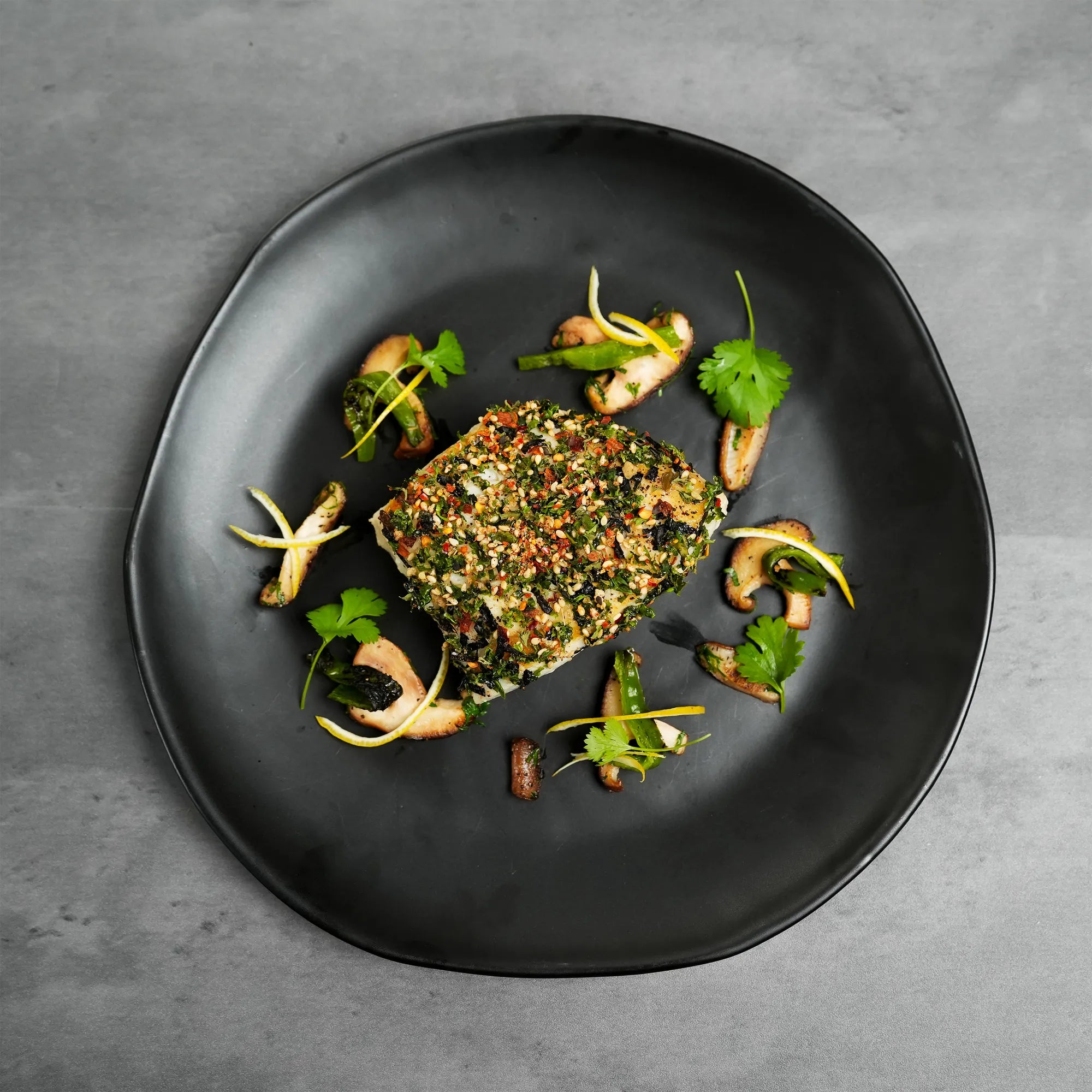 Cooked Foley Chilean Sea Bass Filets on a black plate