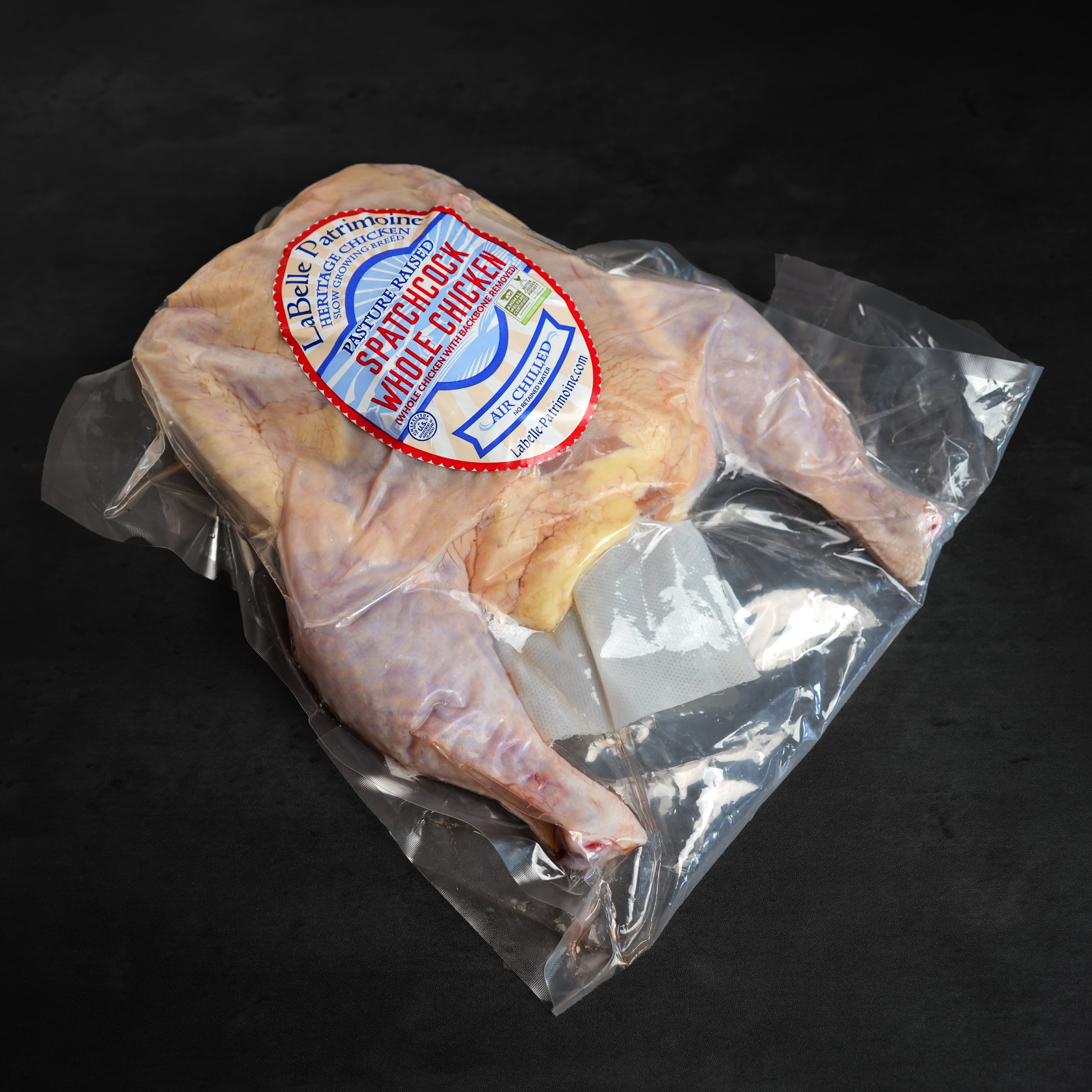 LaBelle Patrimoine Spatchcock Whole Chicken raw in packaging on grey slate background