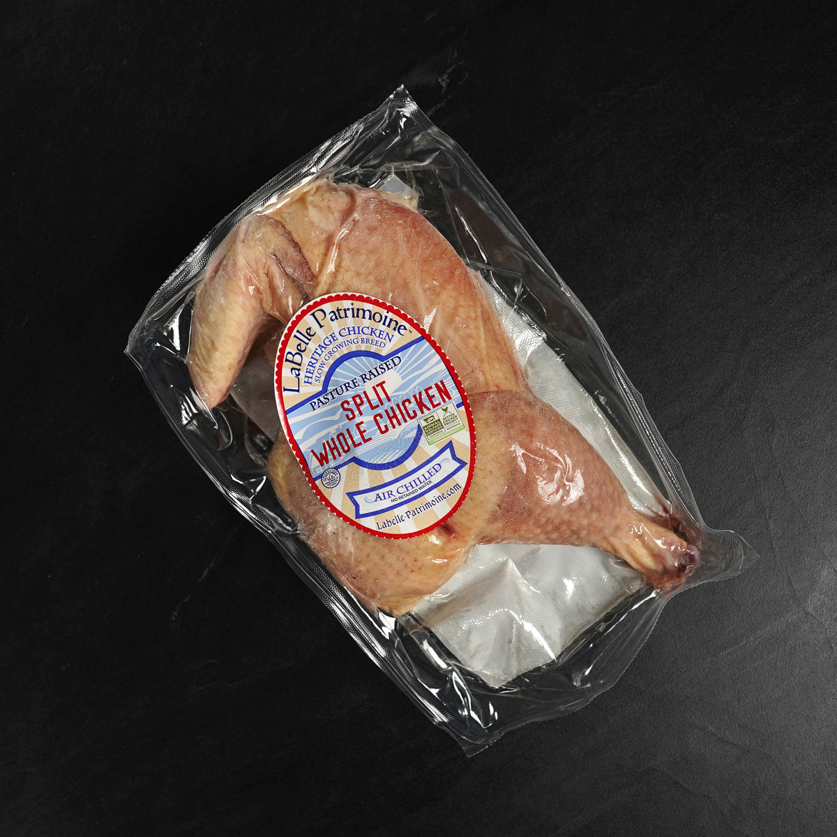 LaBelle Patrimoine Split Whole Chicken raw in packaging on grey slate background