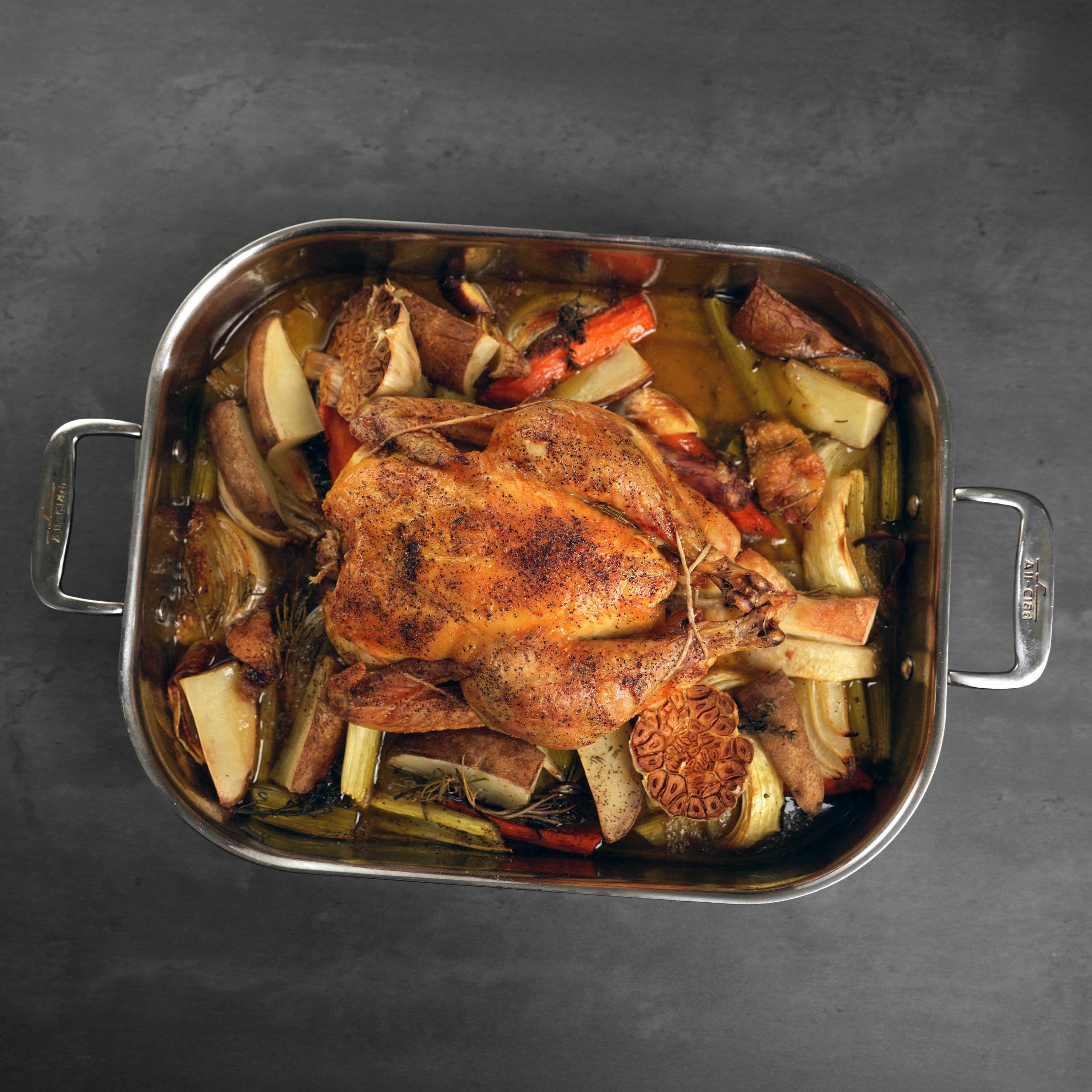 LaBelle Patrimoine Whole Chicken cooked and tied in a prep tray on a grey slate background
