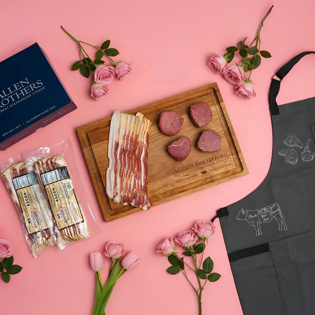 Butcher's display with meat, bacon, and an apron on a pink background with flowers.