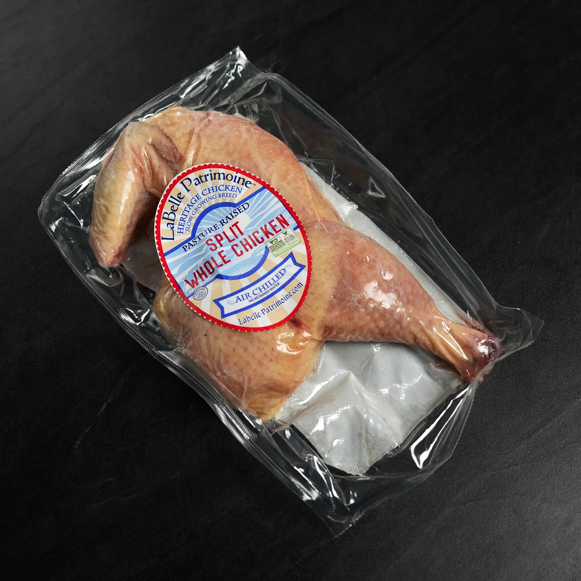 Package of Pasture Raised Heritage Split Chicken, featuring raw breast and leg quarters. Labeled pasture-raised, slow-growing breed, air-chilled; ships frozen.