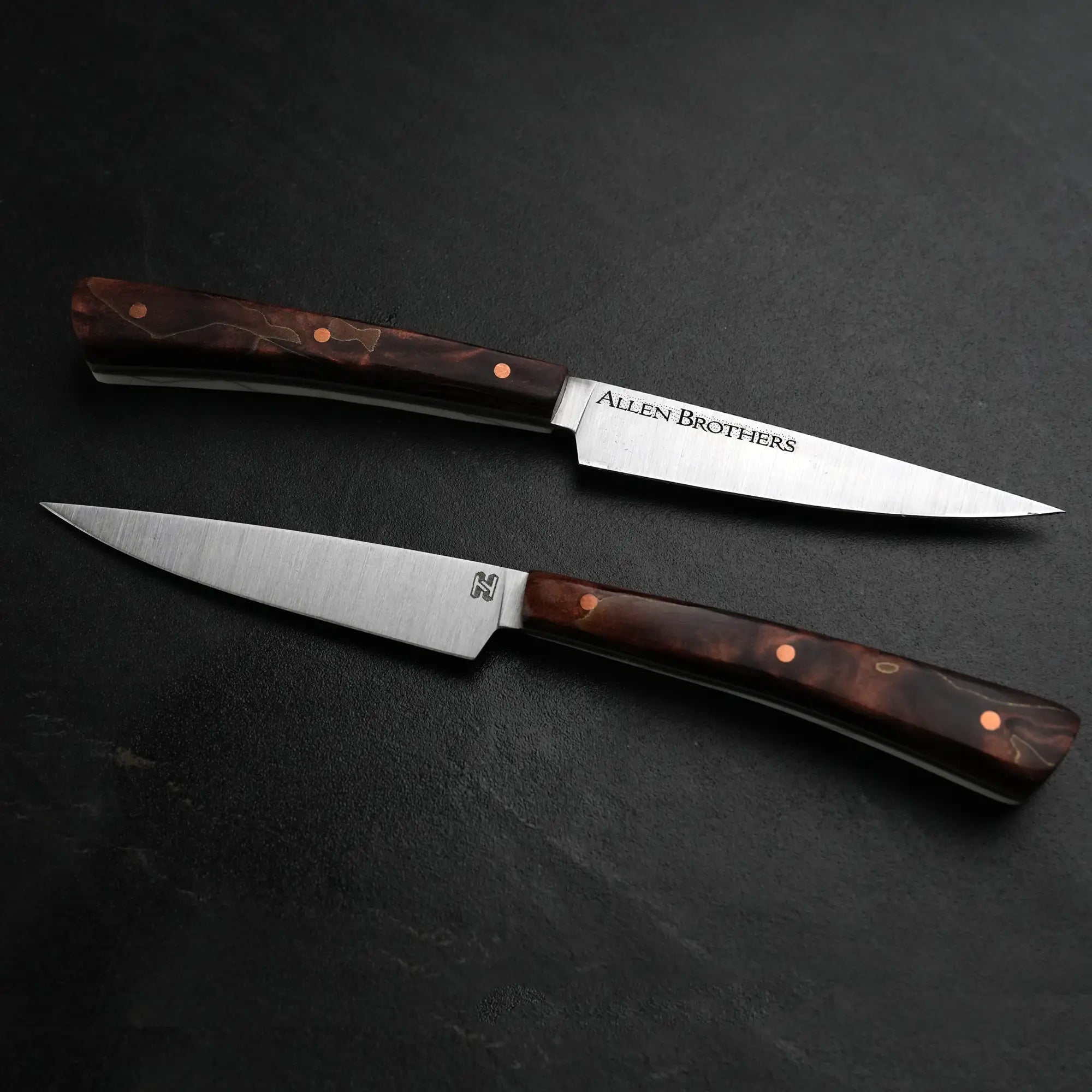 TH Blades Handcrafted Duality Paring Knife Set features two slim knives with stainless-steel blades, dark wood handles, copper rivets, and distinguished branding.