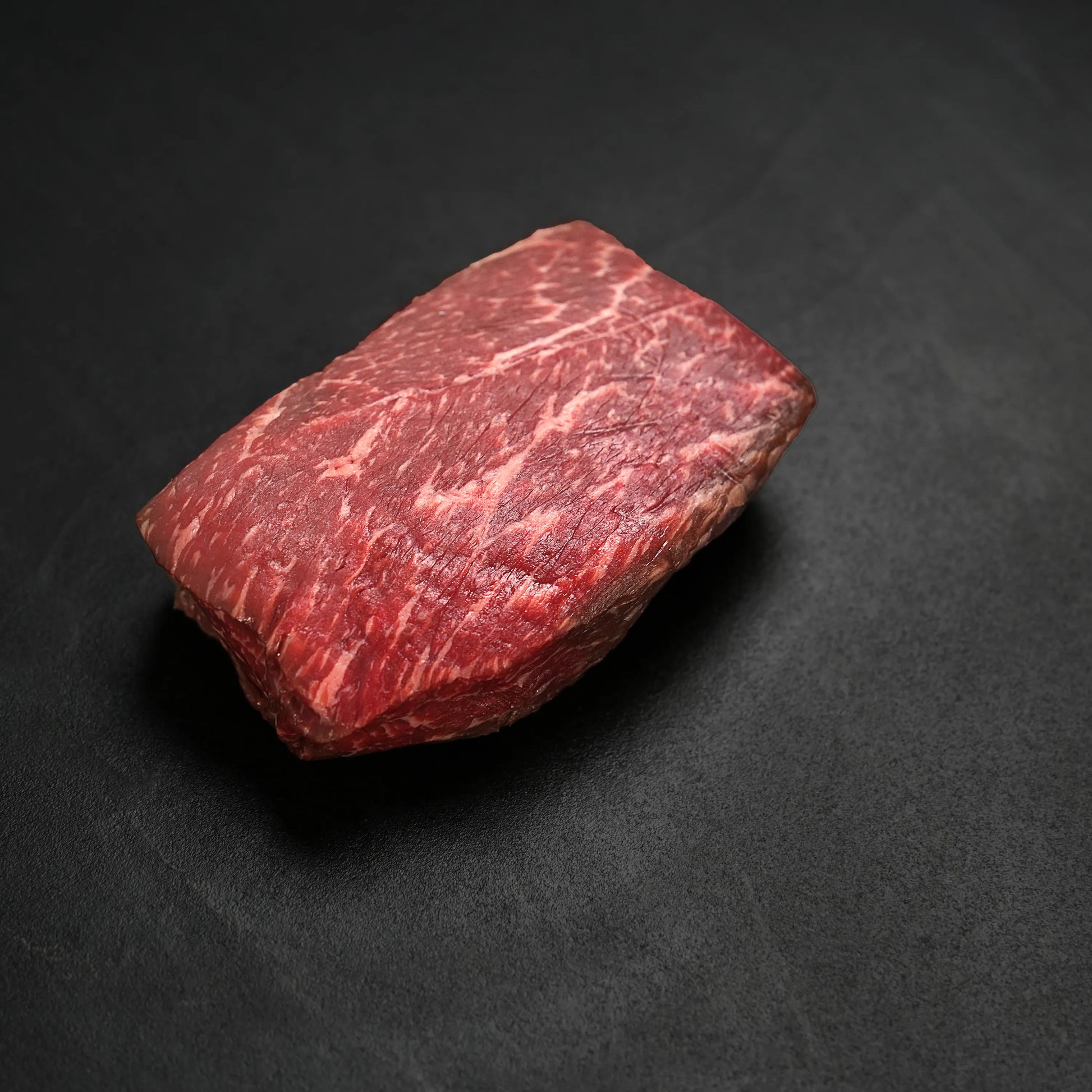 raw steak on black surface