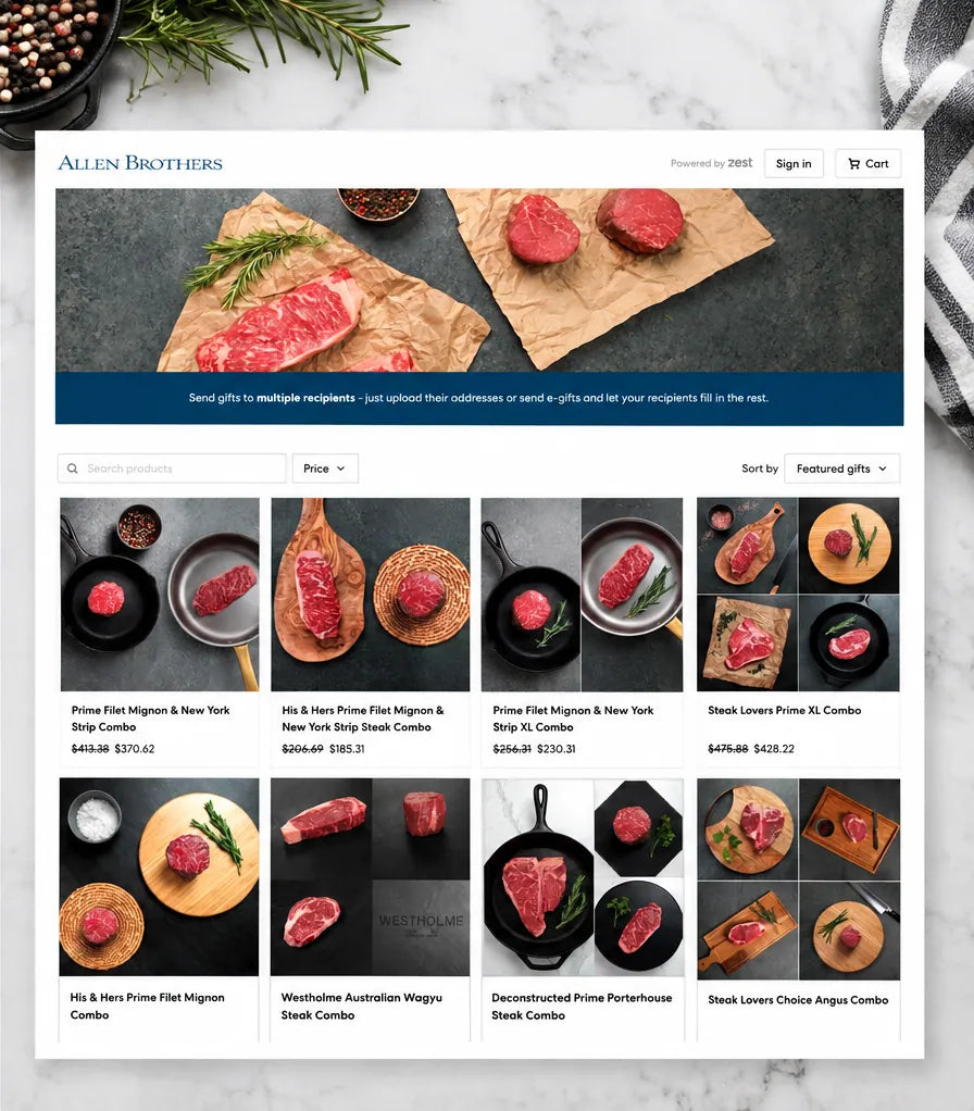 A styled flat-lay mockup of a website homepage for Allen Brothers steaks, showing a hero banner with raw beef patties on parchment paper and a grid of various steak combo products below, set on a white marble background with herbs and a striped napkin.