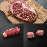 Wagyu Around the World Selection featuring Rosewood Texas Wagyu ribeye, Westholme Australian Wagyu strip steak, and Japanese A5 snow-aged Wagyu cubes.