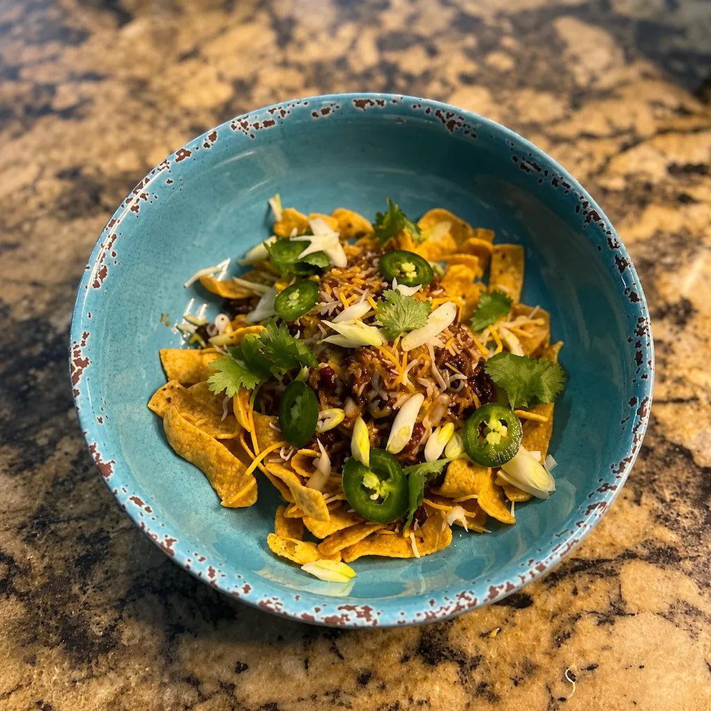 Blue bowl filled with nachos on a marble countertop